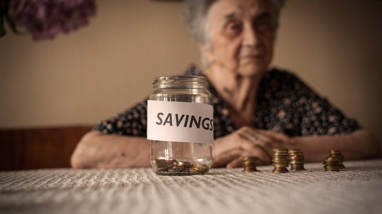 senior next to savings jar