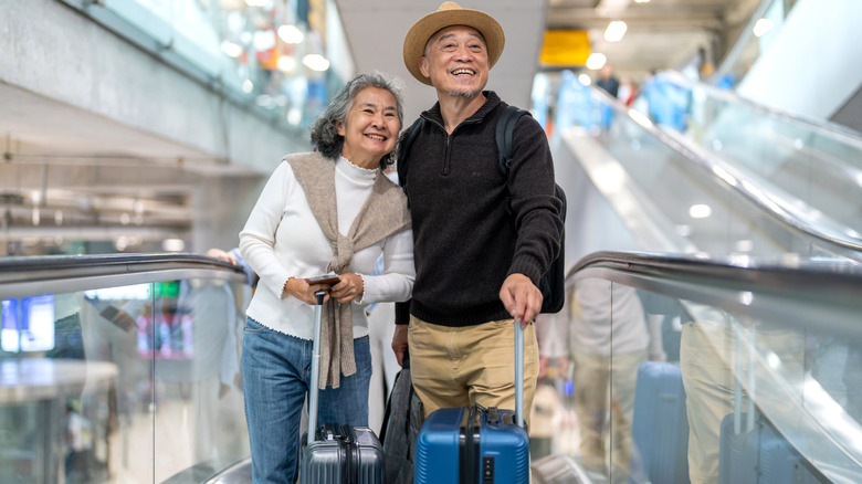 seniors with suitcases traveling