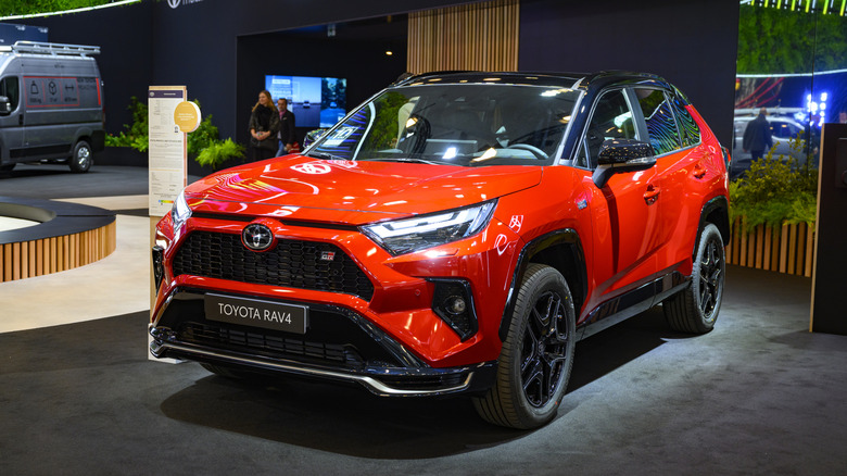 An orange Toyota RAV4 GR Sport crossover hybrid performance SUV on display at the AutoSalon.