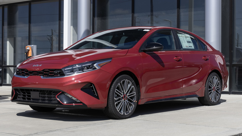 A red Kia Forte displayed at a dealership.