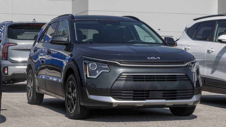 A black Kia Niro Hybrid SUV EX display at a dealership.