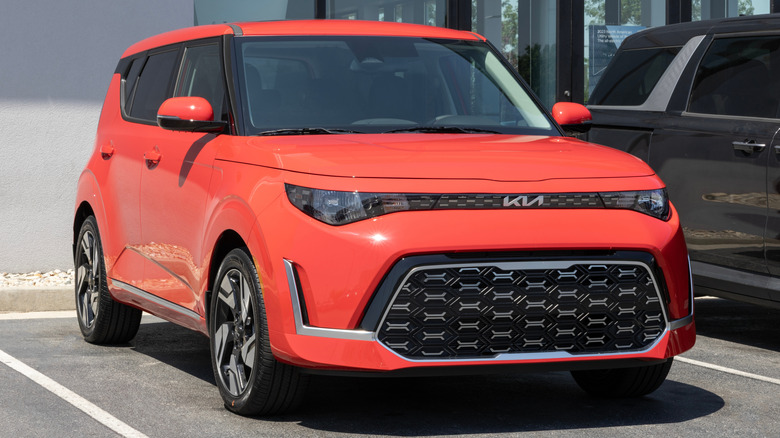 An orange Kia Soul GT-Line Crossover SUV display at a dealership.