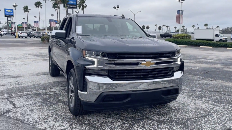 A Black 2021 Chevrolet Silverado 1500 LT Crew Cab parked in front of a busy street