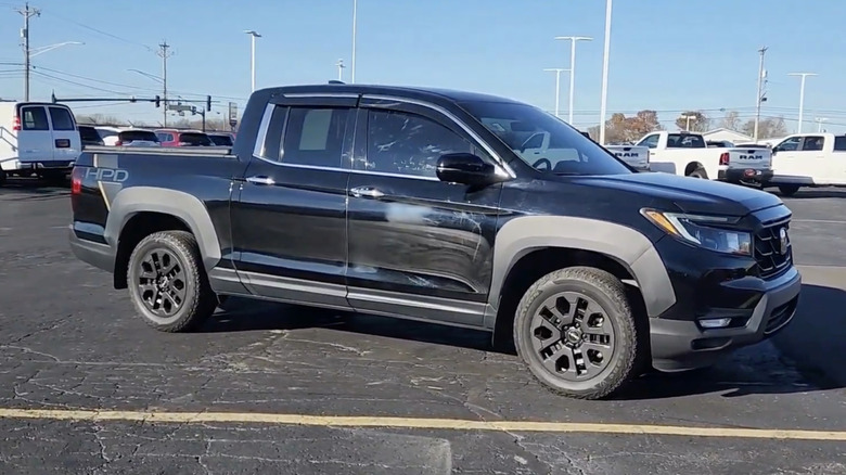 A black 2022 Honda Ridgeline RTL-E parked in a crowded parking lot