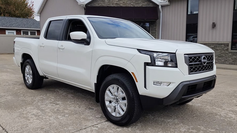 A white 2023 Nissan Frontier SV Crew Cab parked in a driveway