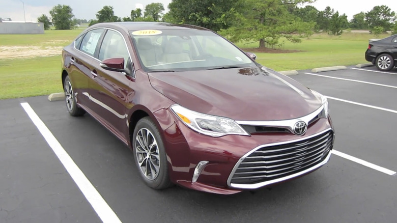 A burgundy 2018 Toyota Avalon XLE Full Tour reverse parked in a field