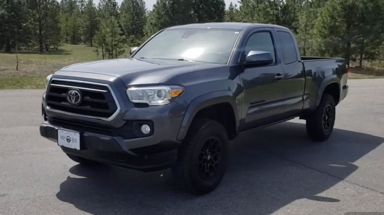 A gray 2020 Toyota Tacoma parked in front of a wooded area