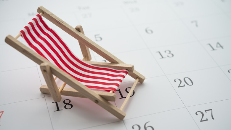 A small foldable red and white chair sitting on a calendar