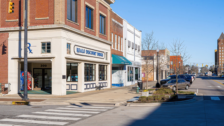 A strip of businesses in Downton Kinston, North Carolina, with cars parked on the street