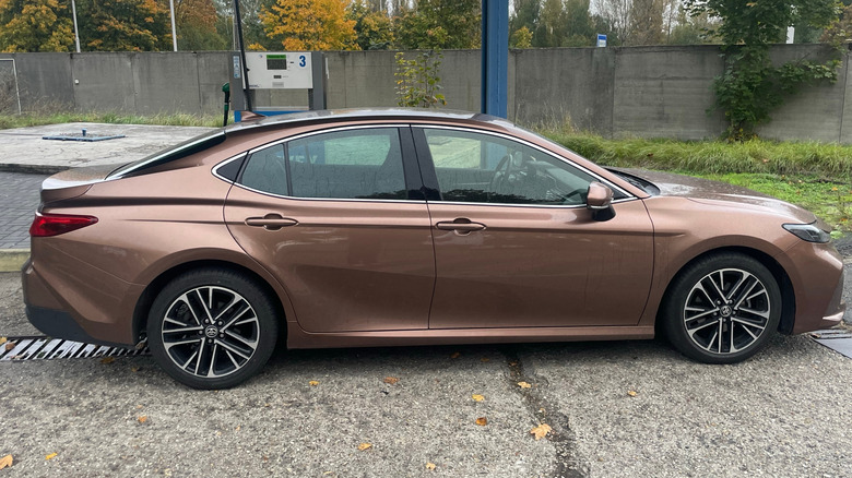 Brown Toyota Camry hybrid car parked on the street.