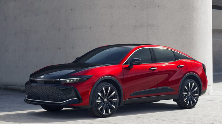 red 2026 Toyota Crown with black trim parked in front of concrete wall