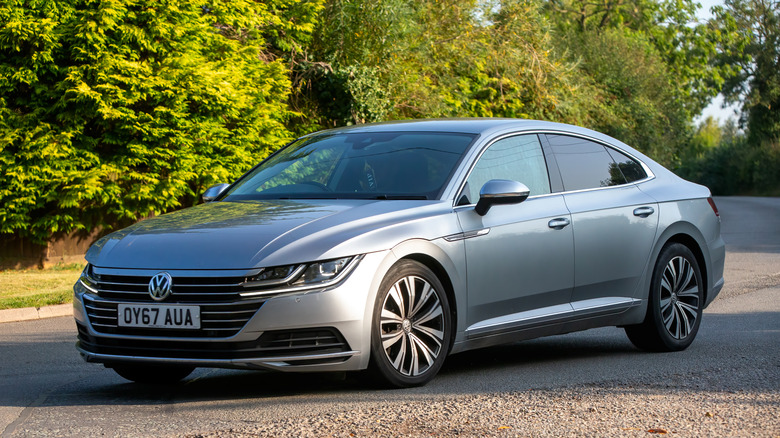 A silver Volkswagen Arteon diesel car driving on a British country road.