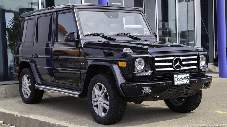 A new Mercedes G550 in front of car dealership.