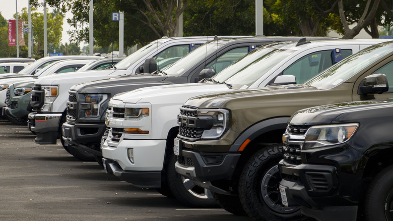 Full-size trucks for sale are parked at a CarMax dealership