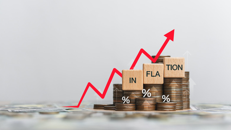 Wooden block and the word inflation on a coin placed