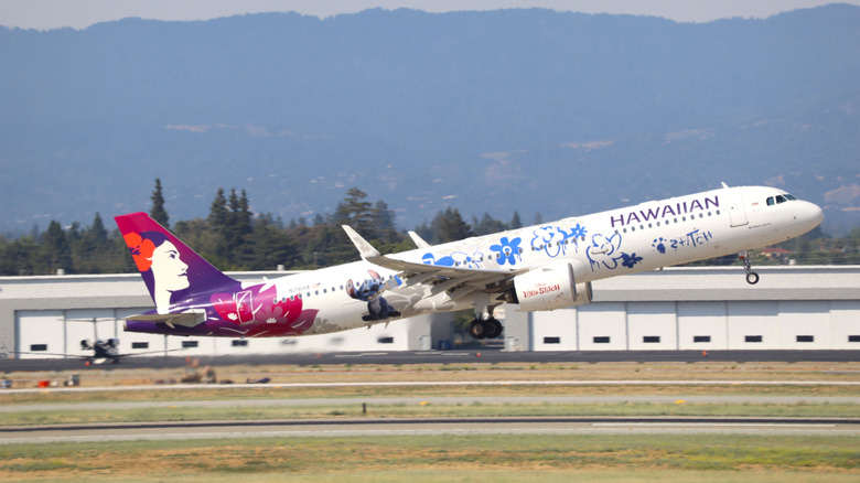 Hawaiian Airlines Airbus A321 neo in Lilo and Stitch livery taking off from San Jose international airport with Santa Cruz mountains in the background,