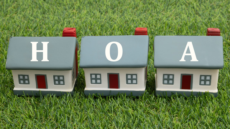 HOA home owners association with three houses on artificial green grass.