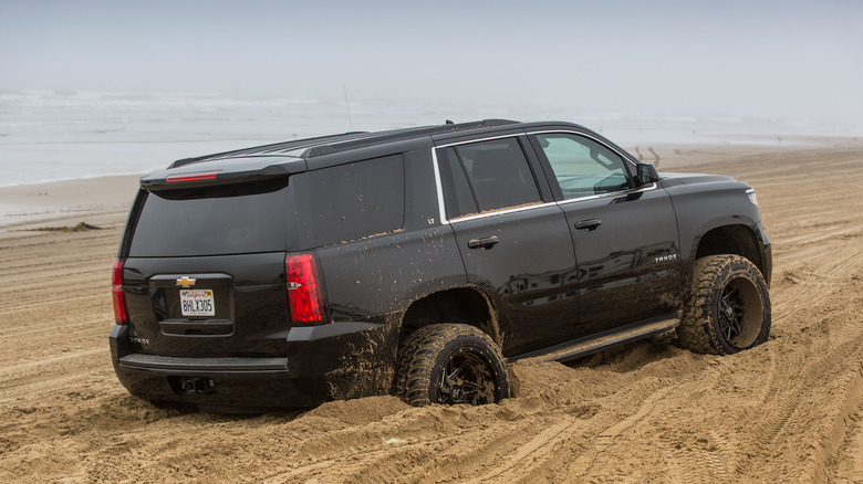 Large SUV trapped in wet sand on the beach