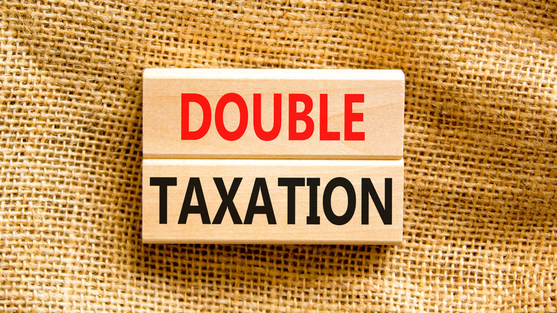 Concept words Double taxation on wooden blocks on a table canvas background.