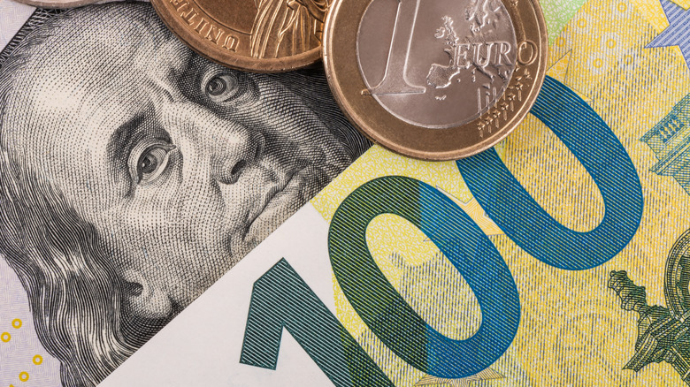 A close up of a 100 dollar bill and a 100 euro bill.