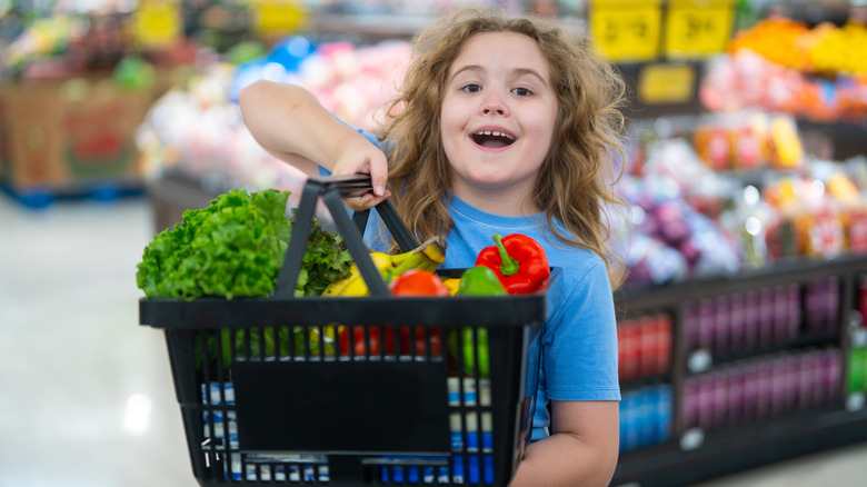 child holding grocery basket