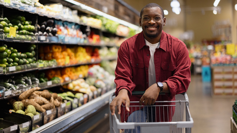 man next to produce aisle in grocery store