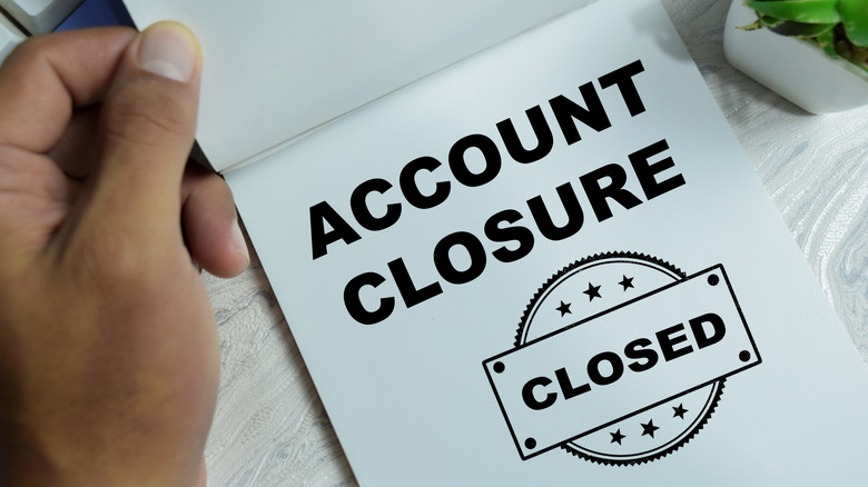 Concept of account closure write on book with closed stamp isolated on wooden table.