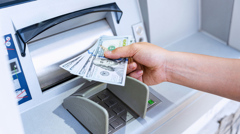 Person taking money out of ATM