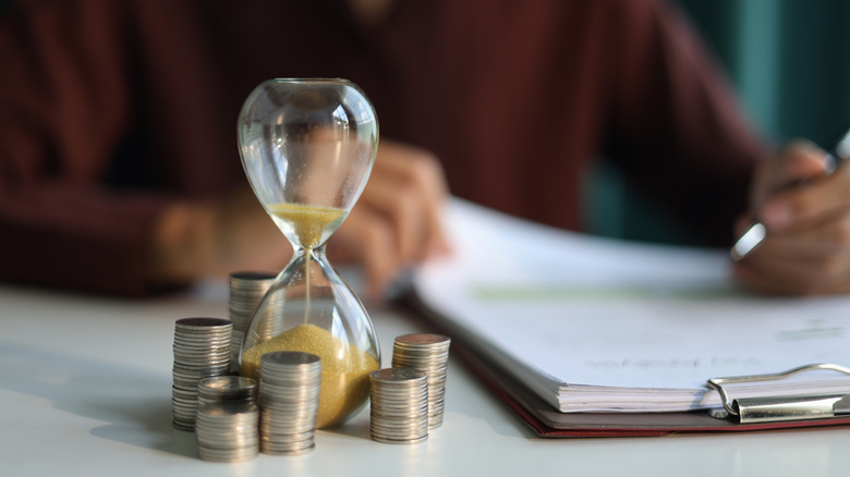 Coin stacks and sand clock on the table.