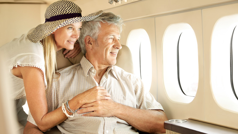 smiling senior couple inside plane