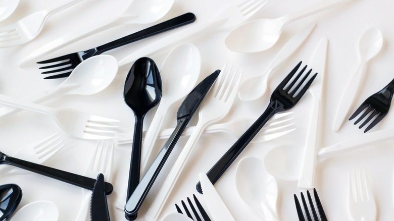 A collection of plastic spoons and forks in dark and light colors