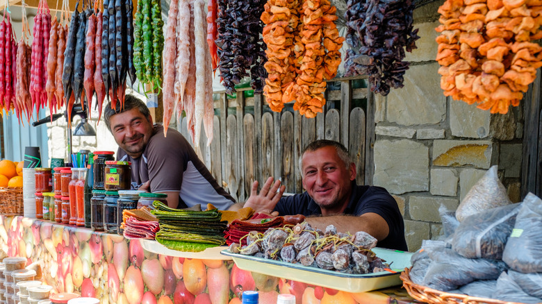 A pair of mature men working behind a food stall in Kutaisi, Georgia.