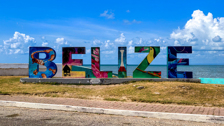 Colorful Belize sign in front of local beach