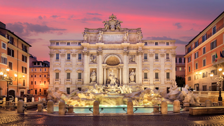 Elaborate fountain in front of historic Roman buildings