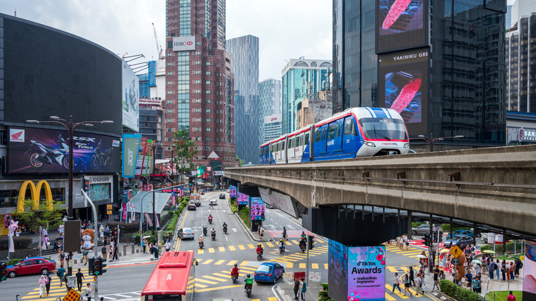 Shot of Kuala Lumpur city area with traffic, McDonald's, and a skyrail train
