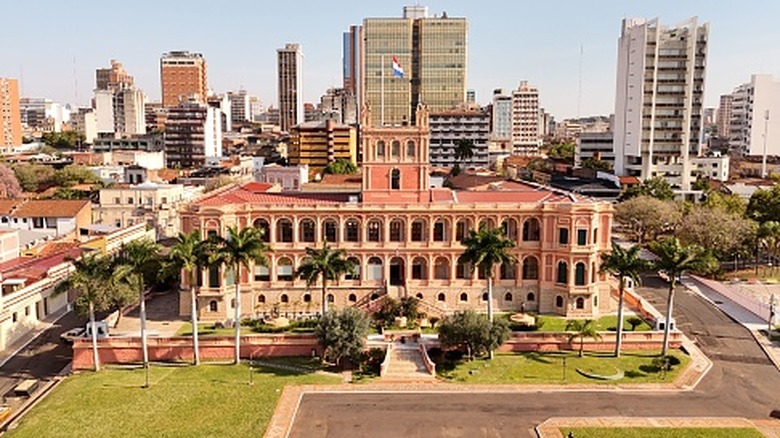 Shot of Paraguay skyline behind building with nation's flag raised