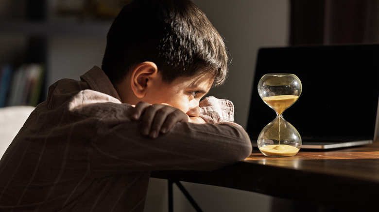 young person looking at an hour glass