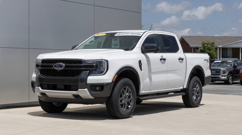 A white Ford Ranger Supercrew 4X4 XLT pickup display at a dealership.