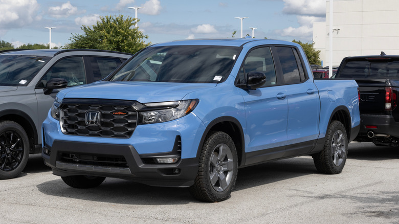 A blue Honda Ridgeline AWD TrailSport display at a dealership.