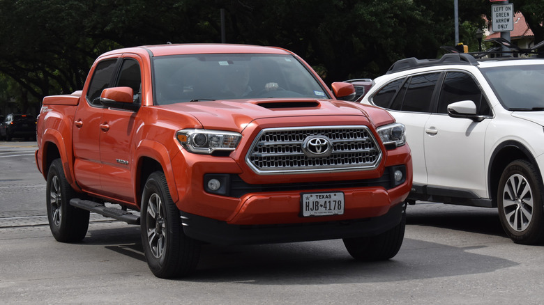A red Toyota Tacoma cruising in near Hermann Park in Houston.