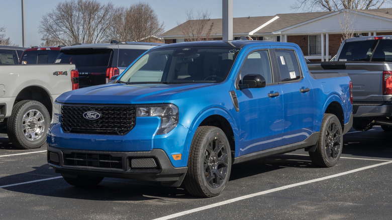 A blue Ford Maverick XLT AWD Hybrid truck display at a dealership.