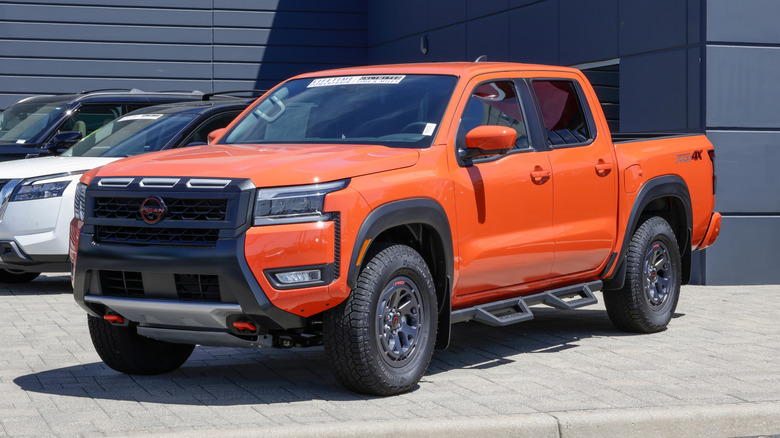 An orange Nissan Frontier PRO-4X Crew Cab 4X4 pickup display.