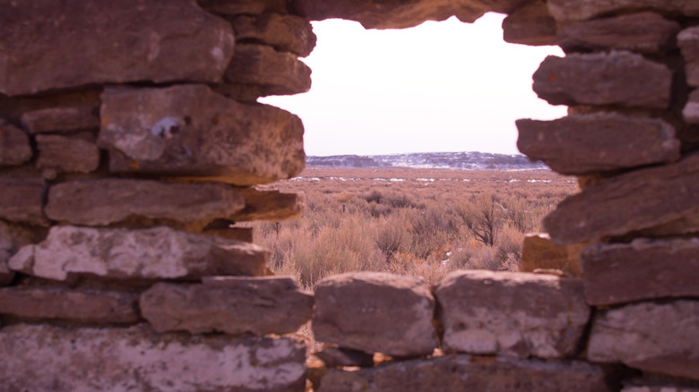 Brown landscape visible through a hole in rocks