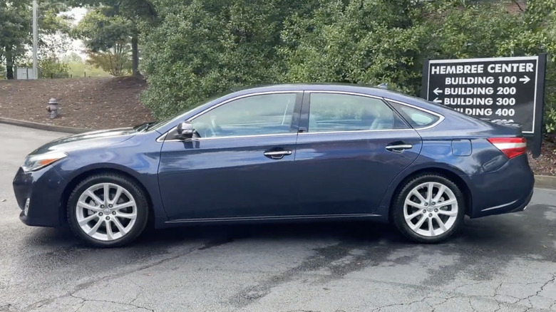 A blue 2015 Toyota Avalon parked outside of a dealership