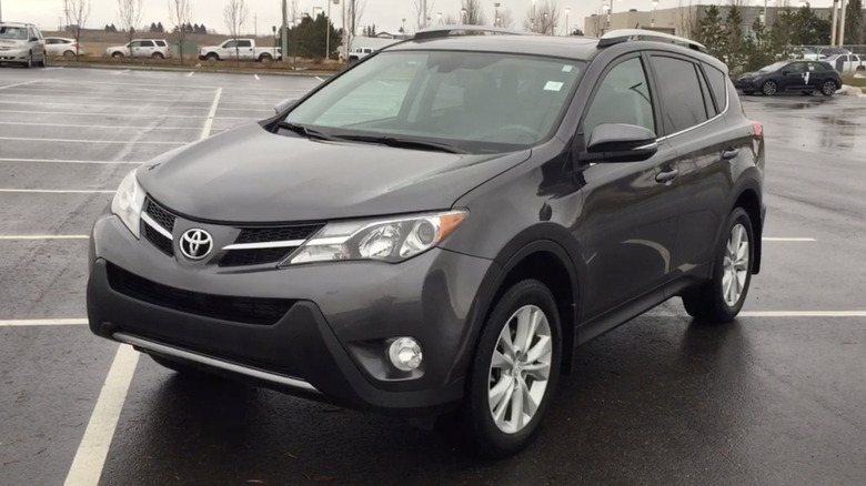 A dark gray 2015 Toyota RAV4 Limited in a parking lot on a rainy day