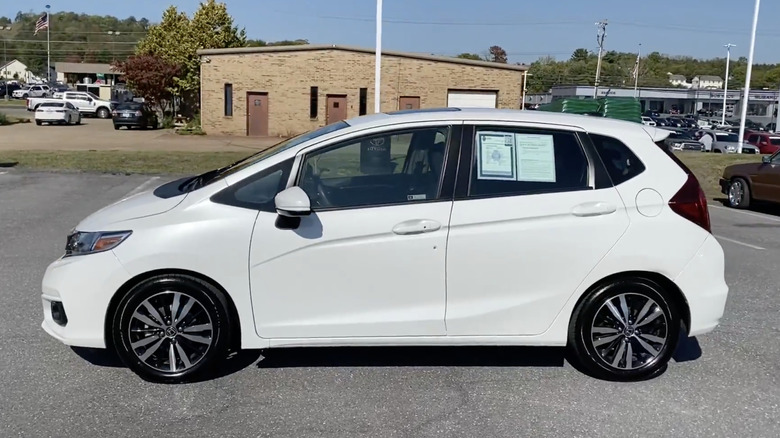 A white 2019 Honda Fit EX parked outside of a dealership
