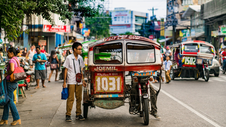 A passenger outside of a bike cab on the streets of Dumaguete in The Philippines