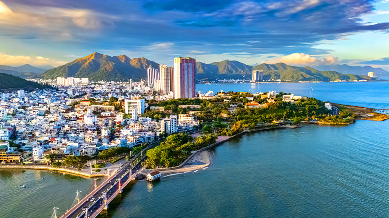 An oceanside aerial view of Nha Trang, Vietnam and multiple homes an buildings on a sunny day