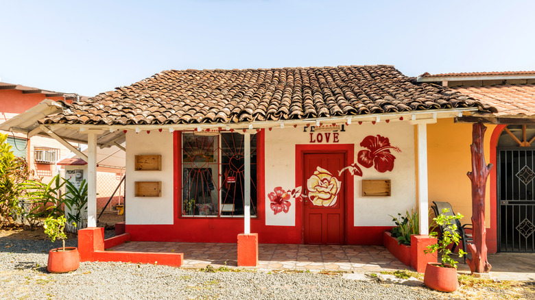 the exterior of a colonial style red and white house on a sunny day in Pedasi, Panama