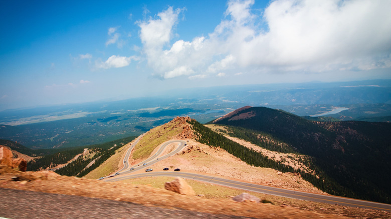 An aerial view of Pike's Peak with vehicles driving on a mountainous road in Cascade-Chipita Park, Colorado.